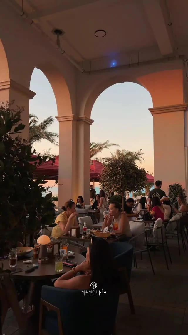 The arcade terrace in the evening: lamps on the tables and a view of the sunset
